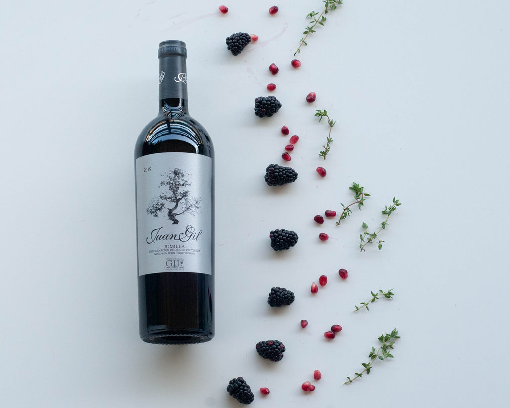 Visual wine tasting notes for Juan Gil Monastrell (Mourevedre) - bottle of wine, blackberry, pomegranate seeds and fresh thyme 