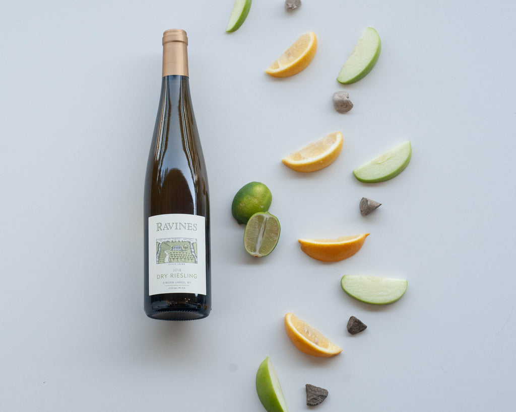 Visual wine tasting notes for Ravines dry Riesling from the Finger Lakes - bottle of wine plus green apple, lemon, lime, and wet stones