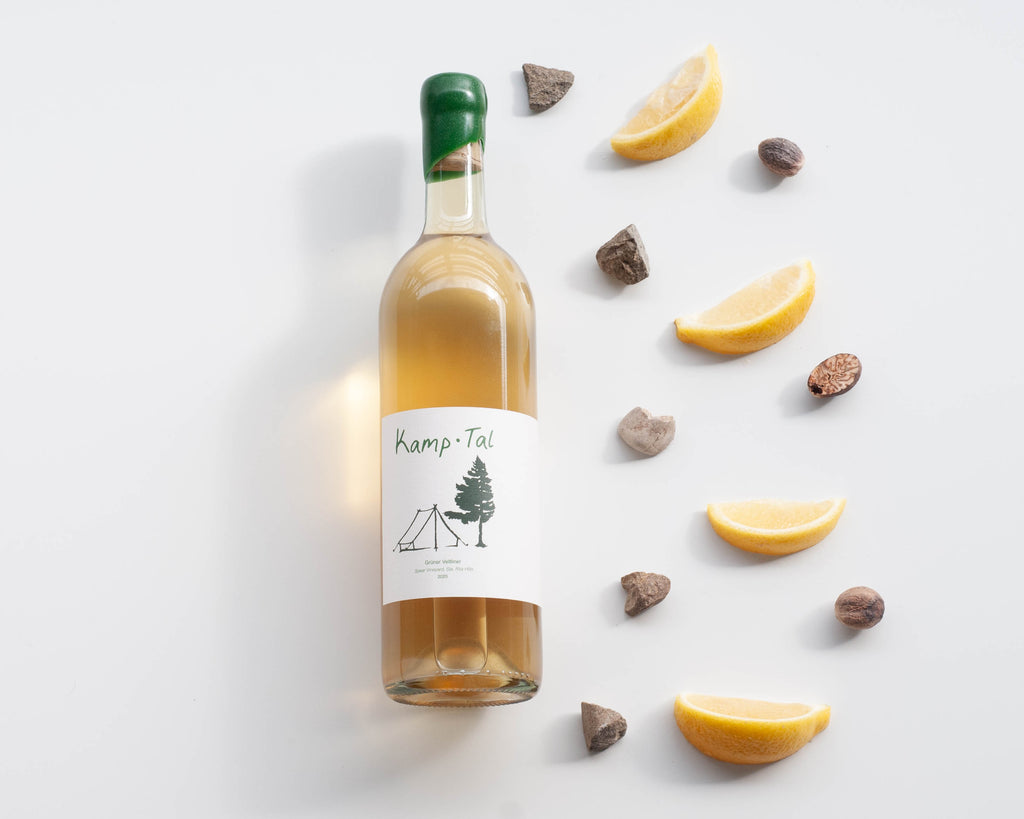 Visual wine tasting notes for Kamp Tal Gruner Veltliner - bottle of wine with lemon, wet stones, and fresh nutmeg 